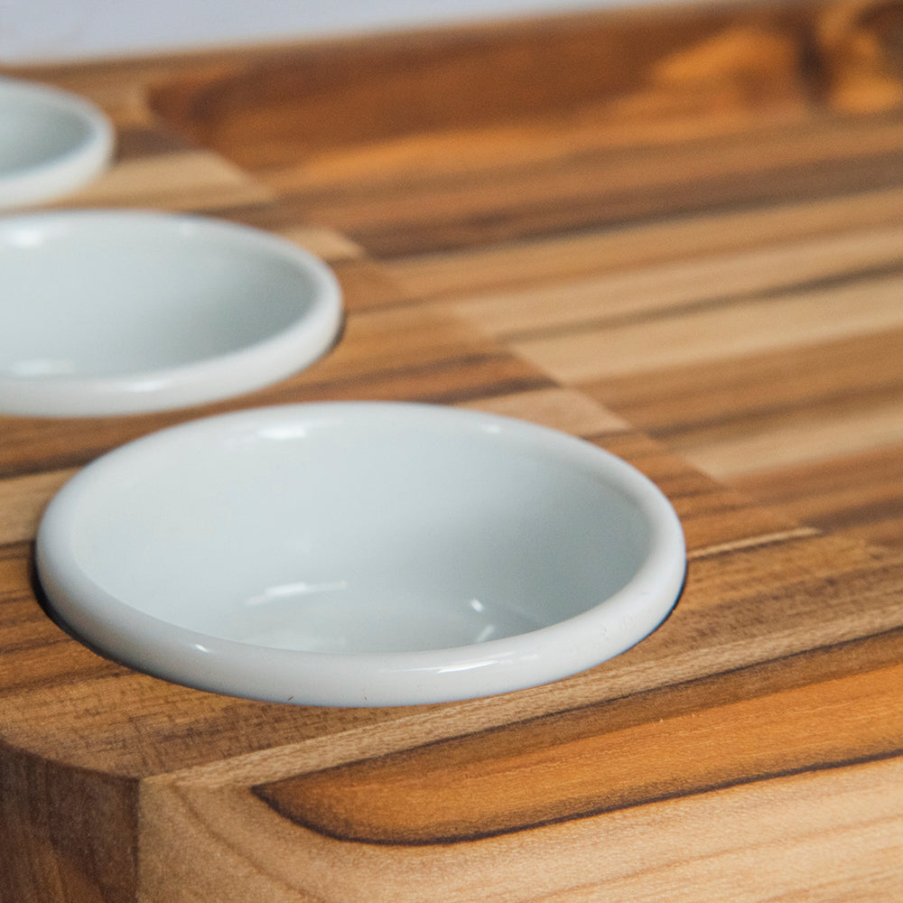 Potes de porcelana brancos sobre bandeja de teca maciça retangular
