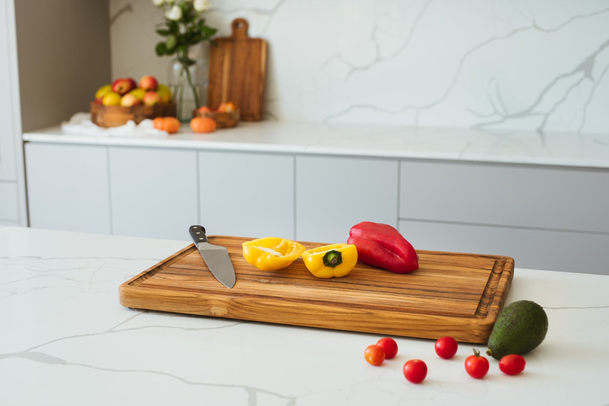 Tábua de corte em madeira teca com legumes e frutos sobre a superfície