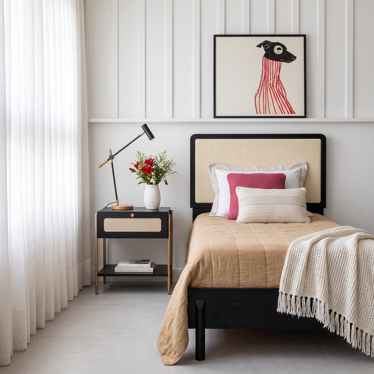 Cama de solteiro na versão de acabamento preto em quarto com mesa de cabeceira, flores e manta clara