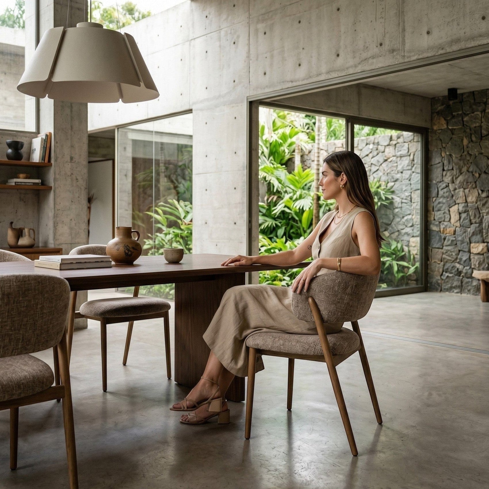 Cadeira estofada clara em ambiente interno, com pés de madeira e encosto alto
