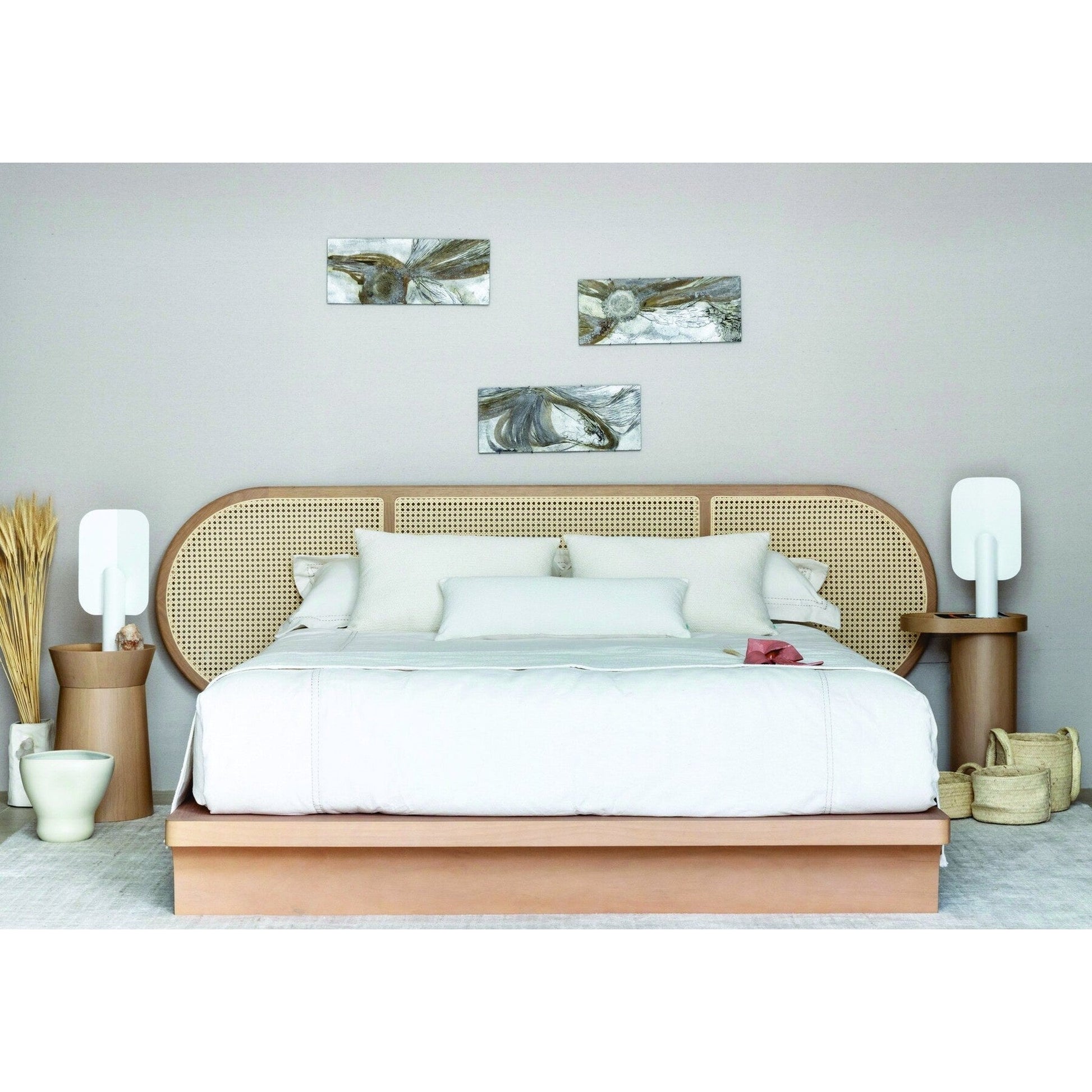 Cama Brisa com roupa de cama branca, cabeceira arredondada de palhinha e apoio lateral.