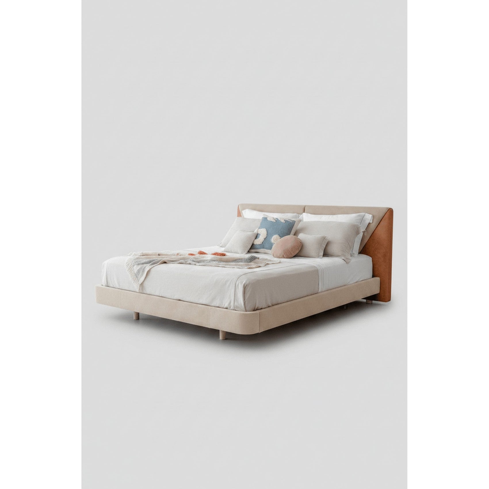 Cama estofada bege com cabeceira alta, pés discretos e travesseiros com capas claras.