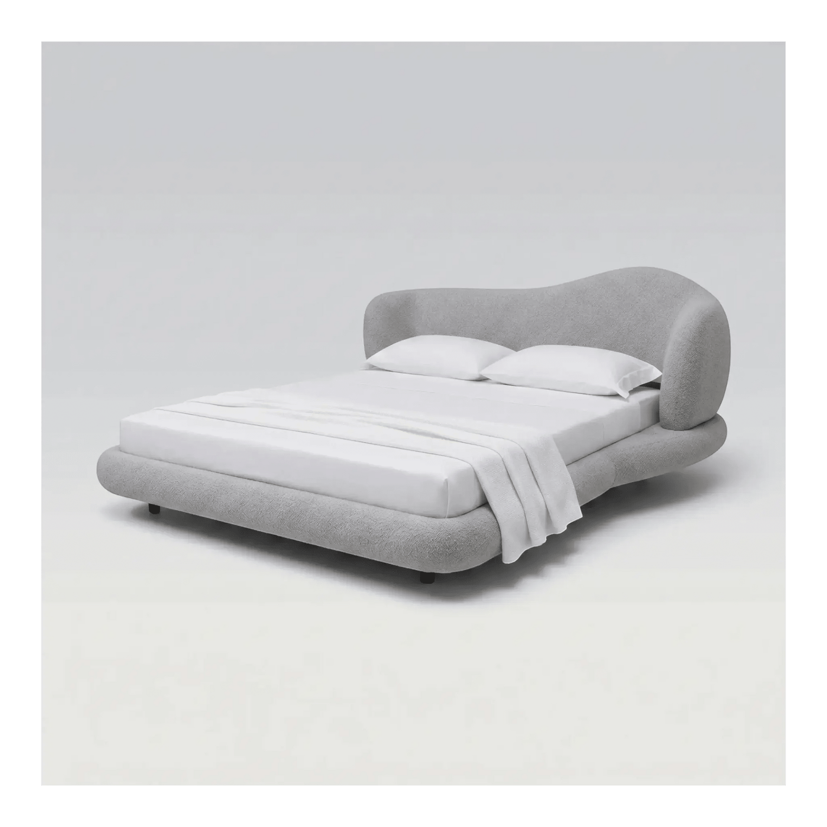 Cama estofada cinza com cabeceira curva e base baixa, lençóis e travesseiros brancos.