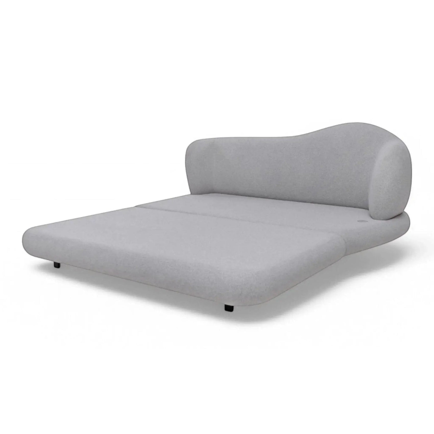 Cama estofada cinza com cabeceira arredondada e base baixa, travesseiros brancos.