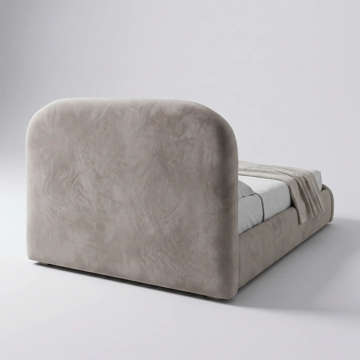 Cama estofada clara vista lateral, com cabeceira alta e base acolchoada