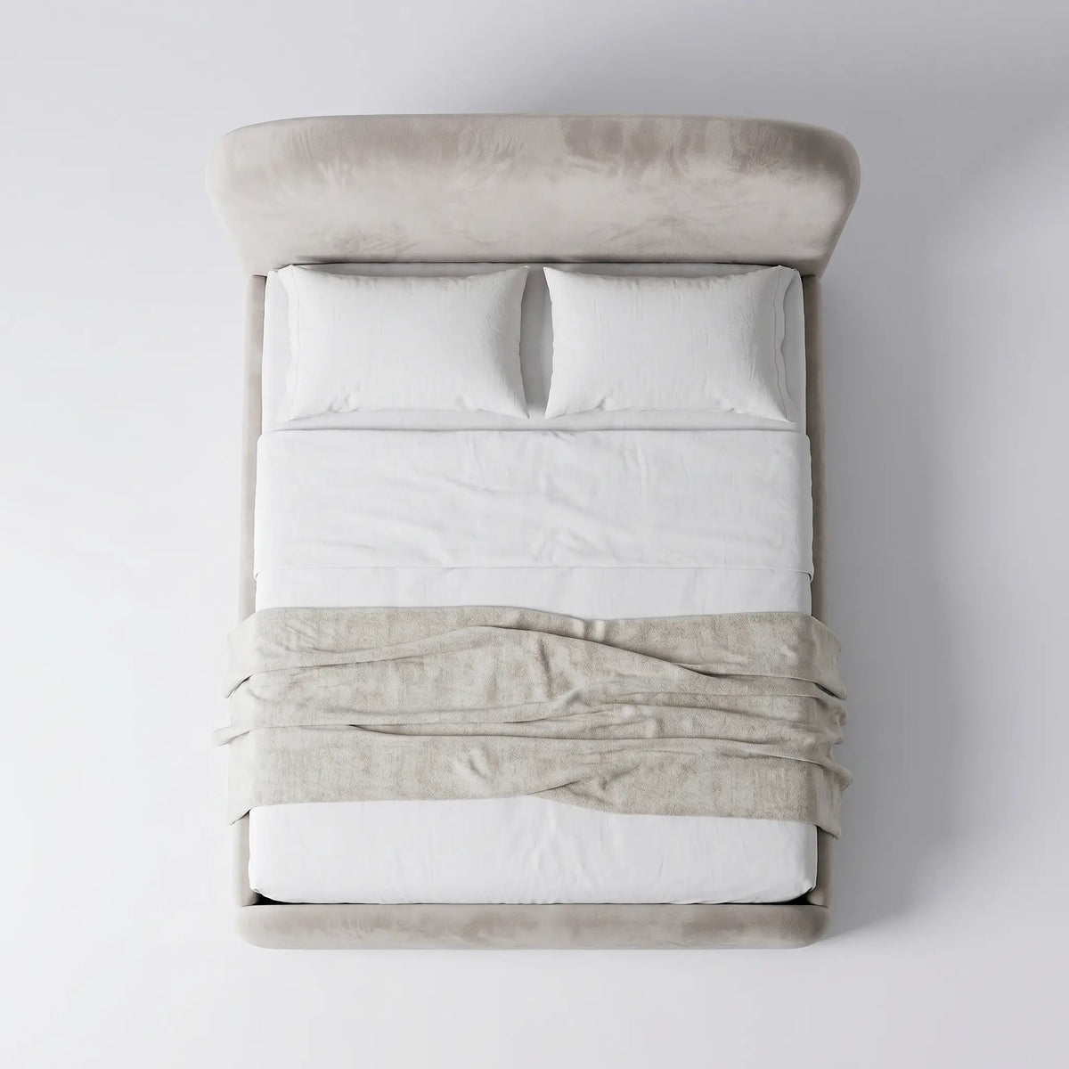 Cama estofada com roupa de cama branca e manta dobrada sobre o colchão