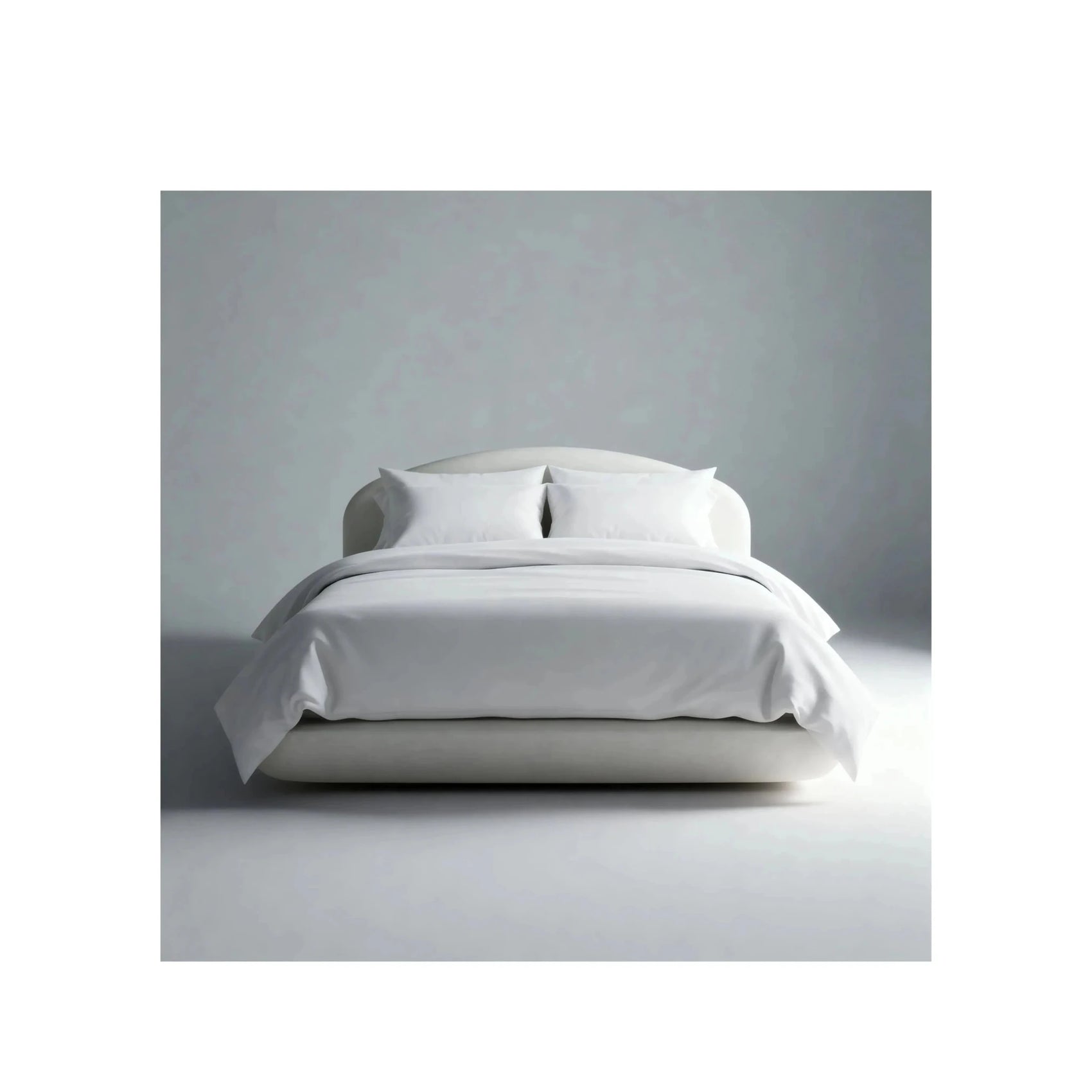 Cama estofada clara com cabeceira baixa arredondada e lençol branco dobrado