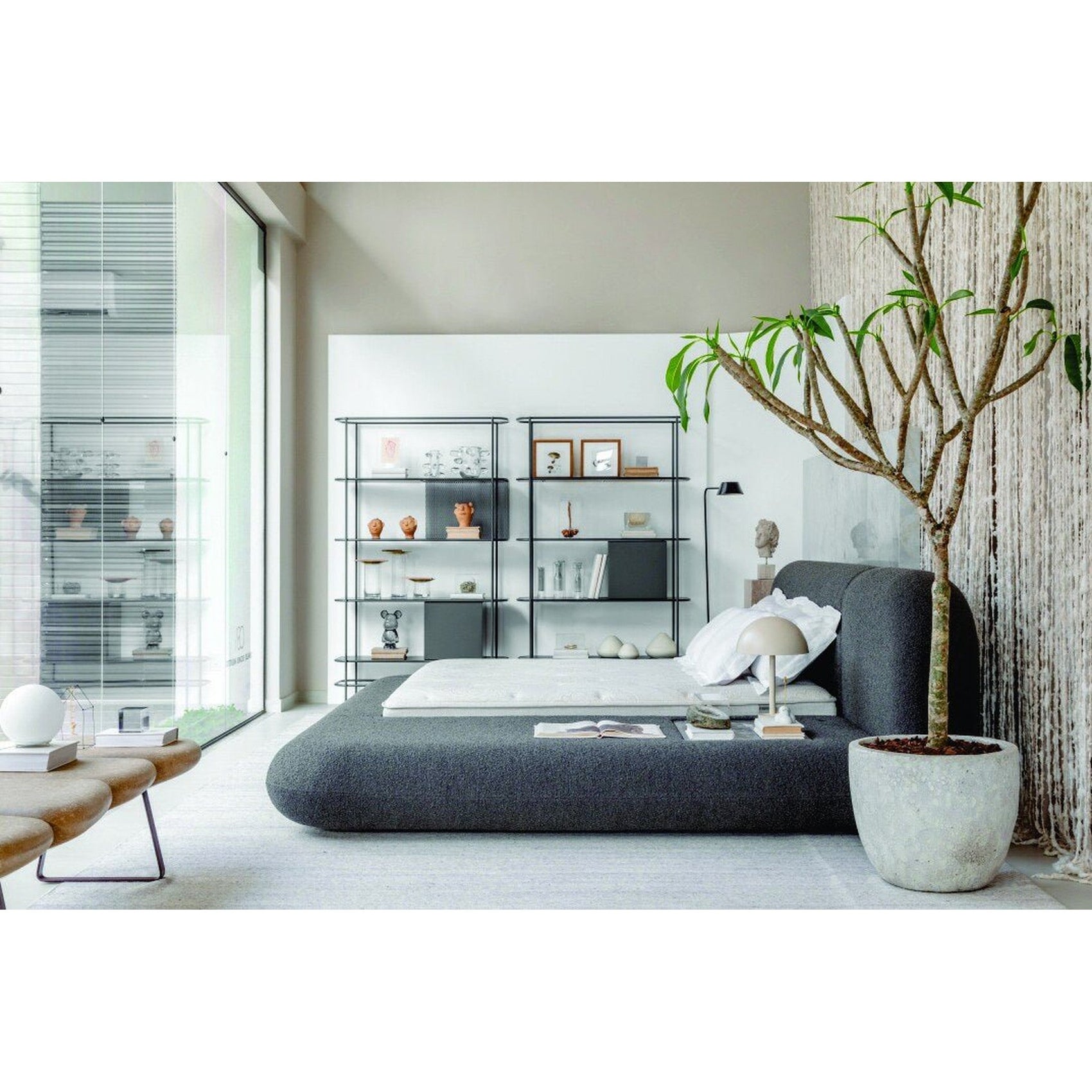 Cama orgânica estofada cinza com roupa de cama branca e cabeceira alta