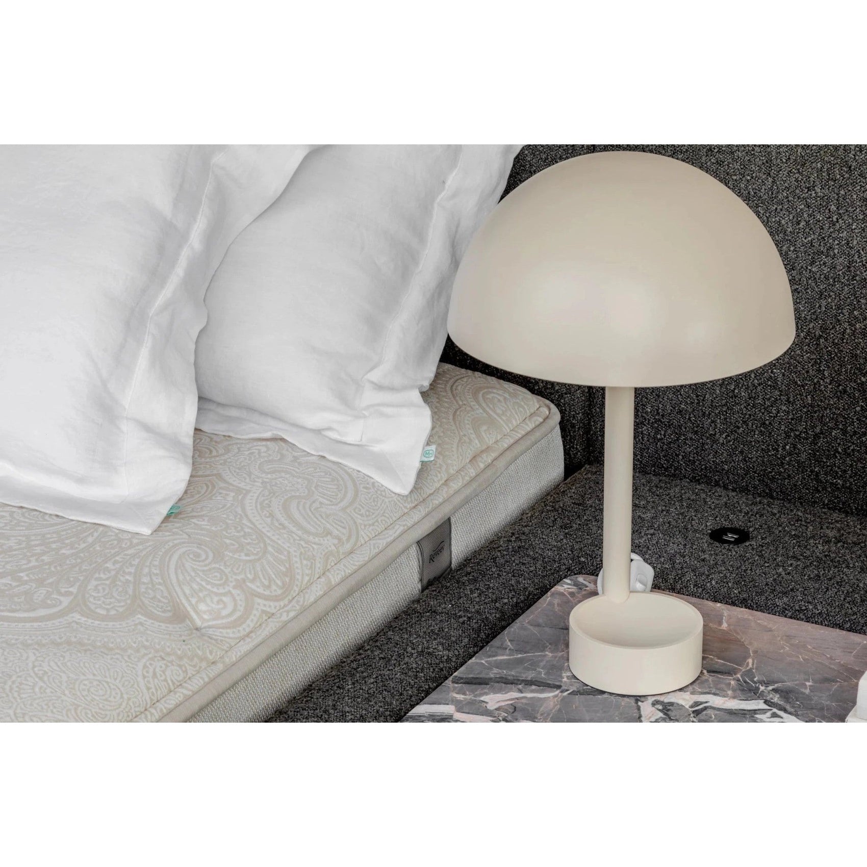 Cama orgânica estofada cinza com roupa de cama branca e base lateral