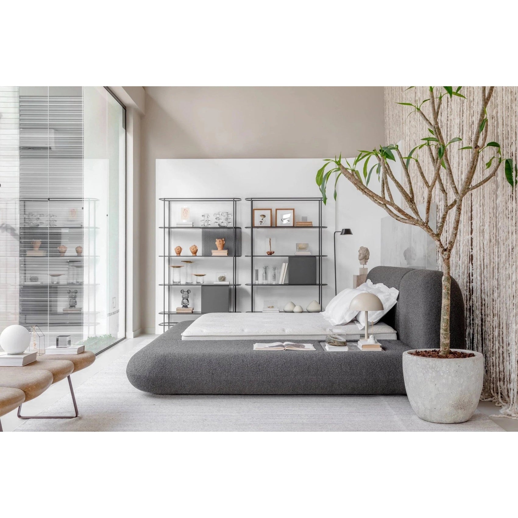 Cama orgânica estofada cinza com roupa de cama branca e cabeceira alta