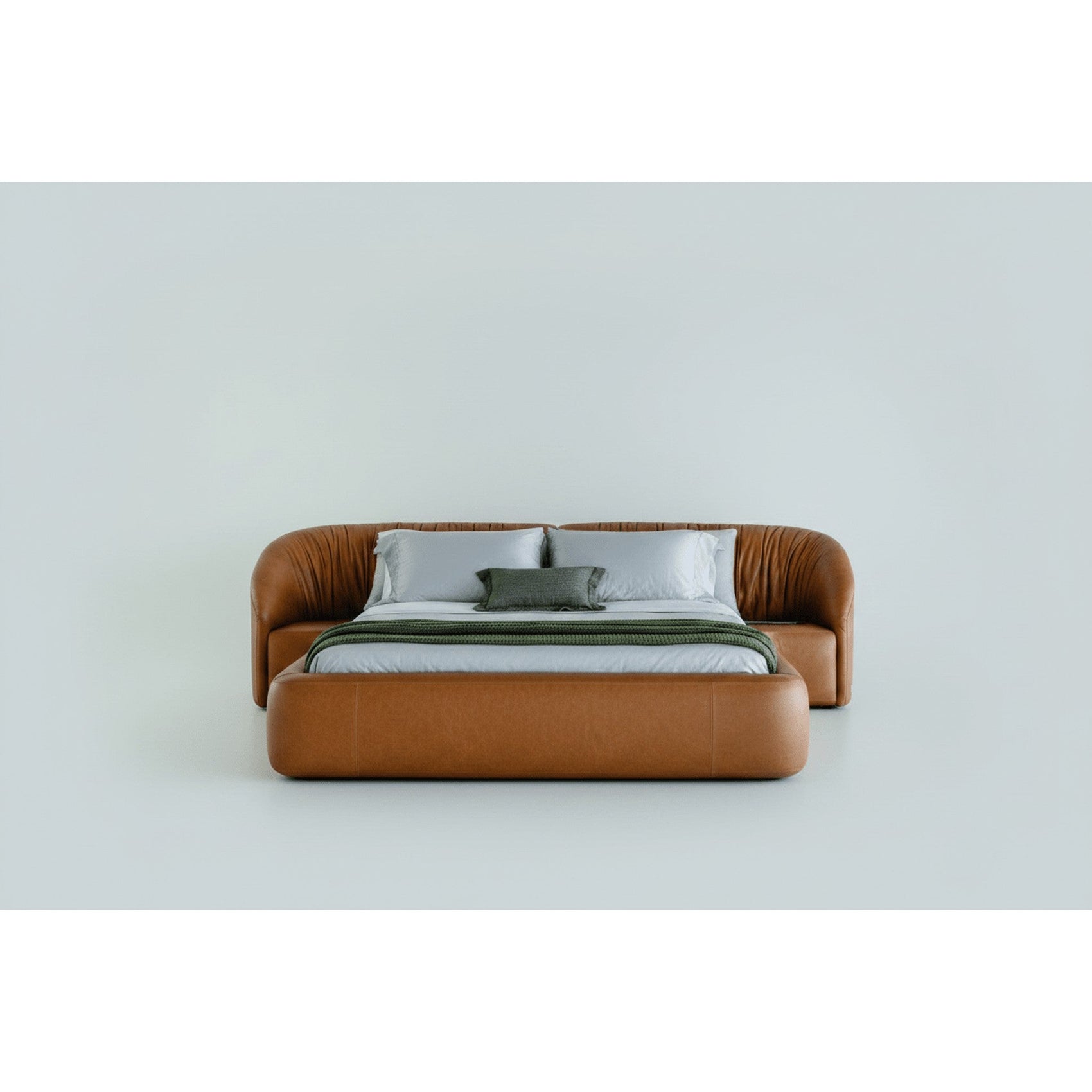 Cama estofada marrom com roupa de cama clara e travesseiros cinza, vista frontal.