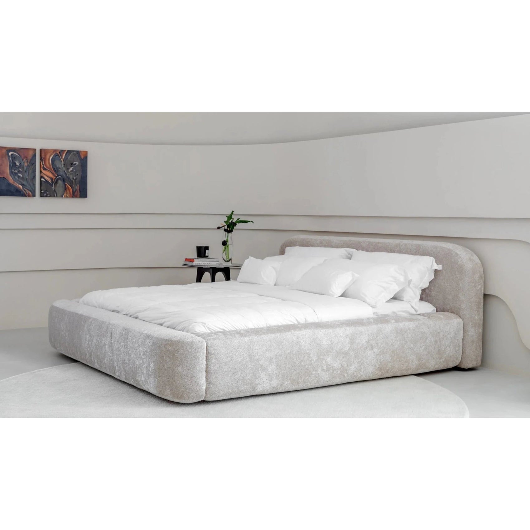 Cama estofada cinza claro com cabeceira curvada e colcha branca