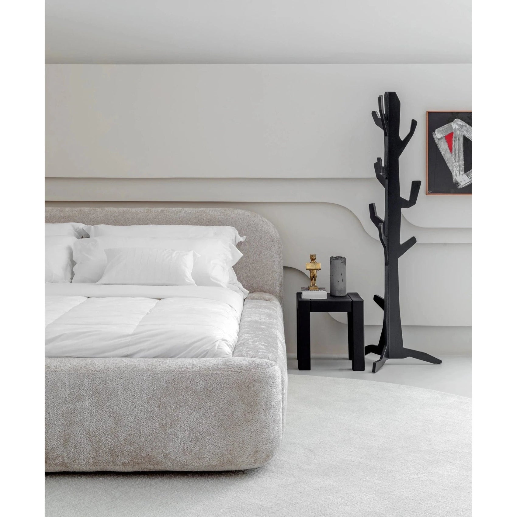 Cama estofada cinza claro com lateral larga e roupa de cama branca