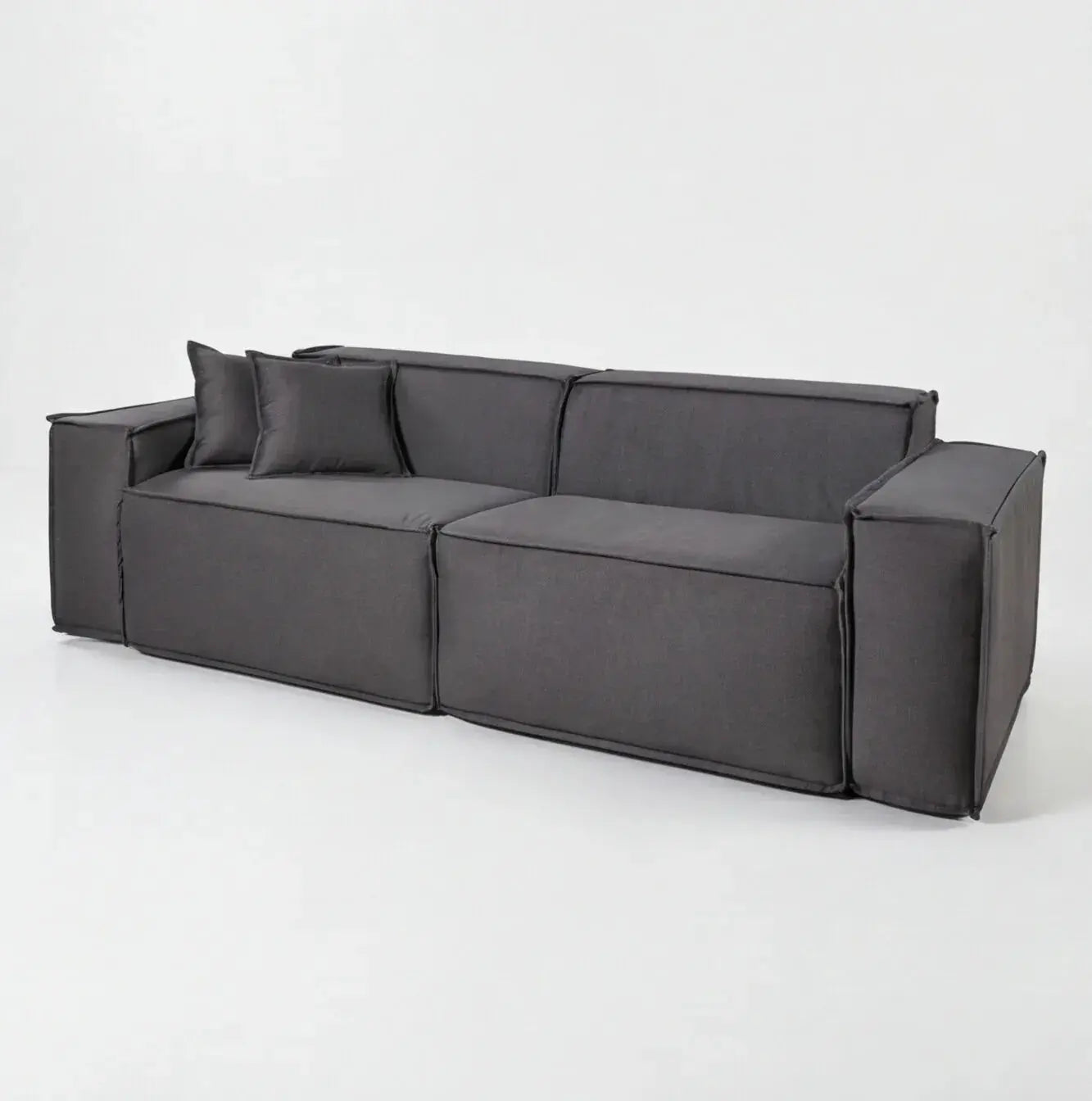 Sofá modular cinza escuro com design contemporâneo, almofadas e acabamento moderno em ambiente minimalista.