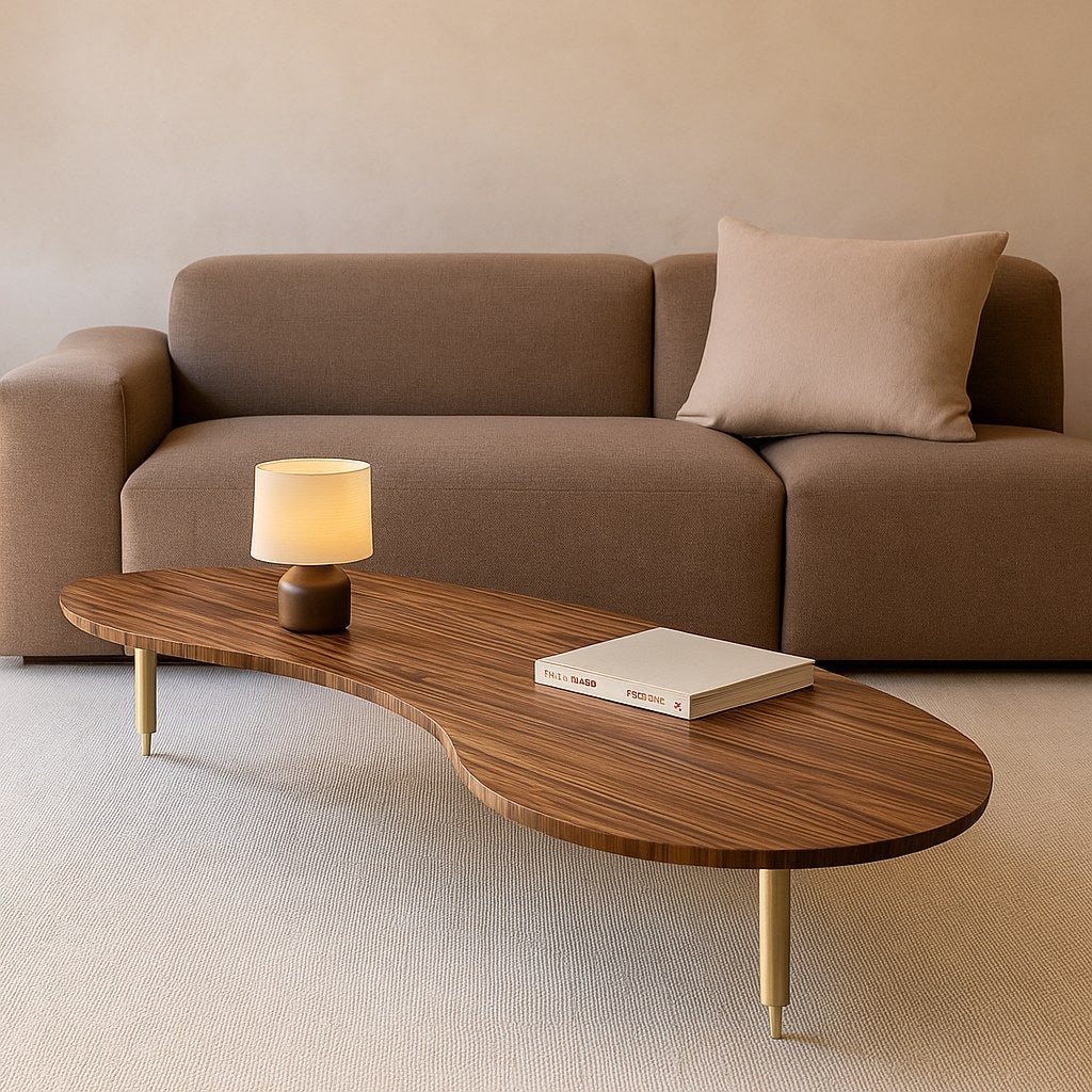 Mesa de centro orgânica em sala de estar com sofá, luminária de mesa e livro sobre o tampo