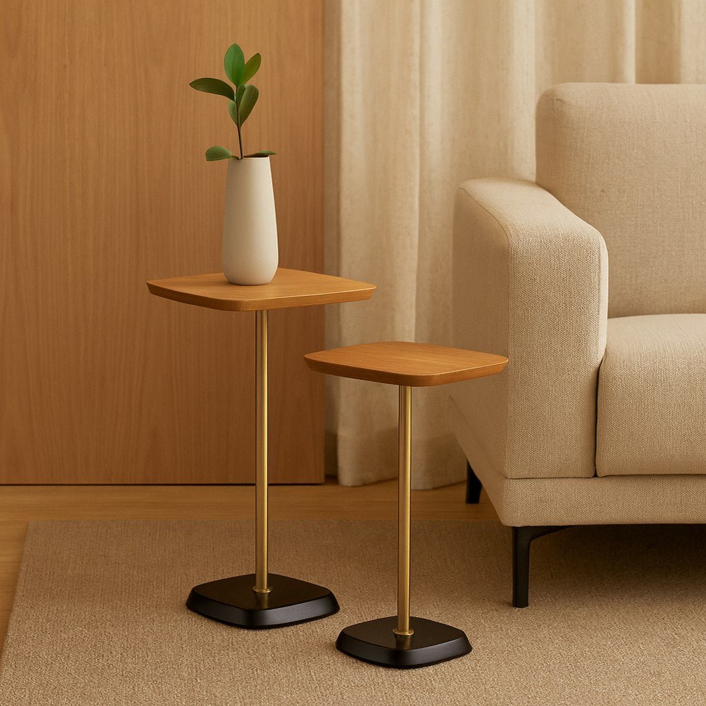 Conjunto de mesas laterais ao lado de sofá em sala de estar com vaso de planta, cortina e tapete