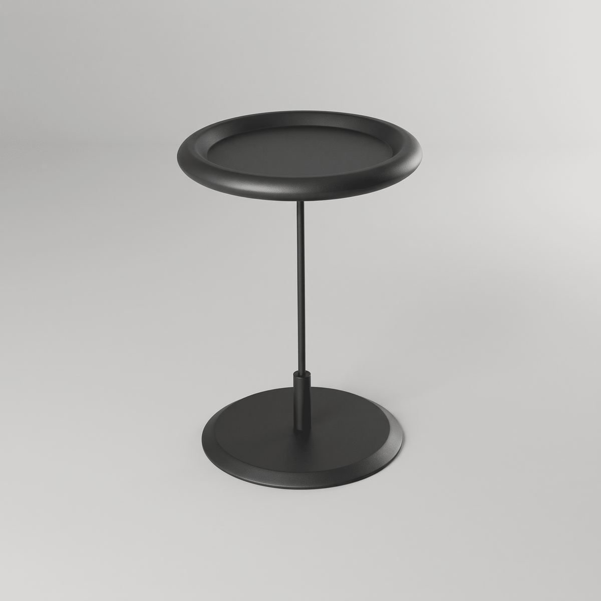 Mesa lateral de tampo redondo com borda elevada sobre haste fina de aço, vista de três quartos
