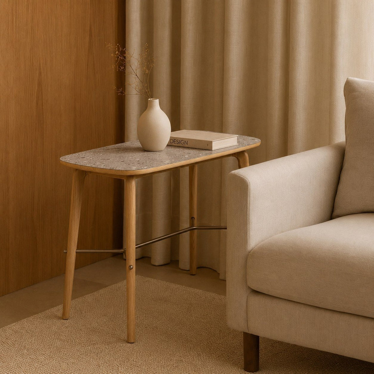 Mesa lateral de tampo texturizado e pés de madeira em sala de estar com poltrona, vaso e livro