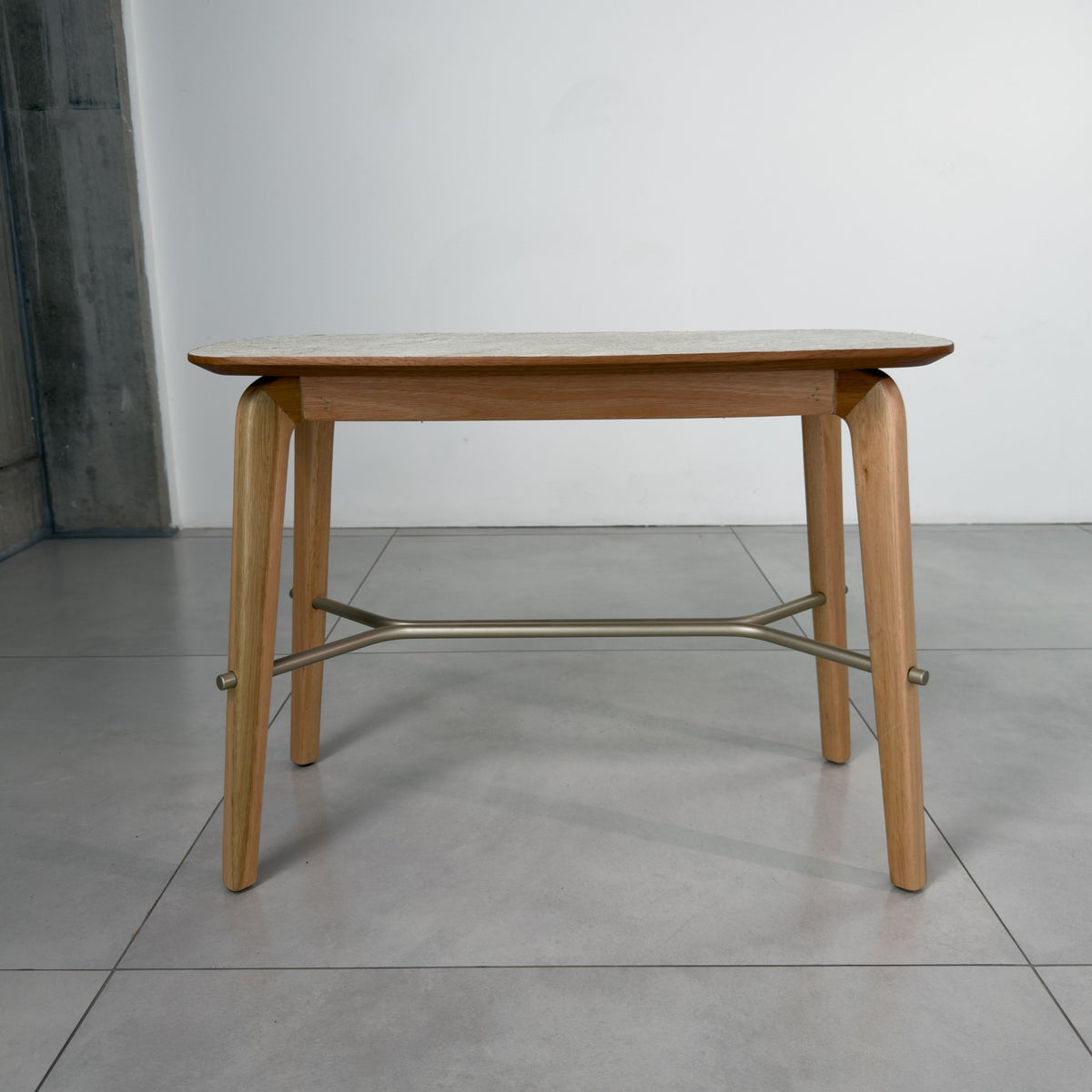 Mesa lateral de tampo texturizado com pés de madeira e travessa metálica, vista frontal