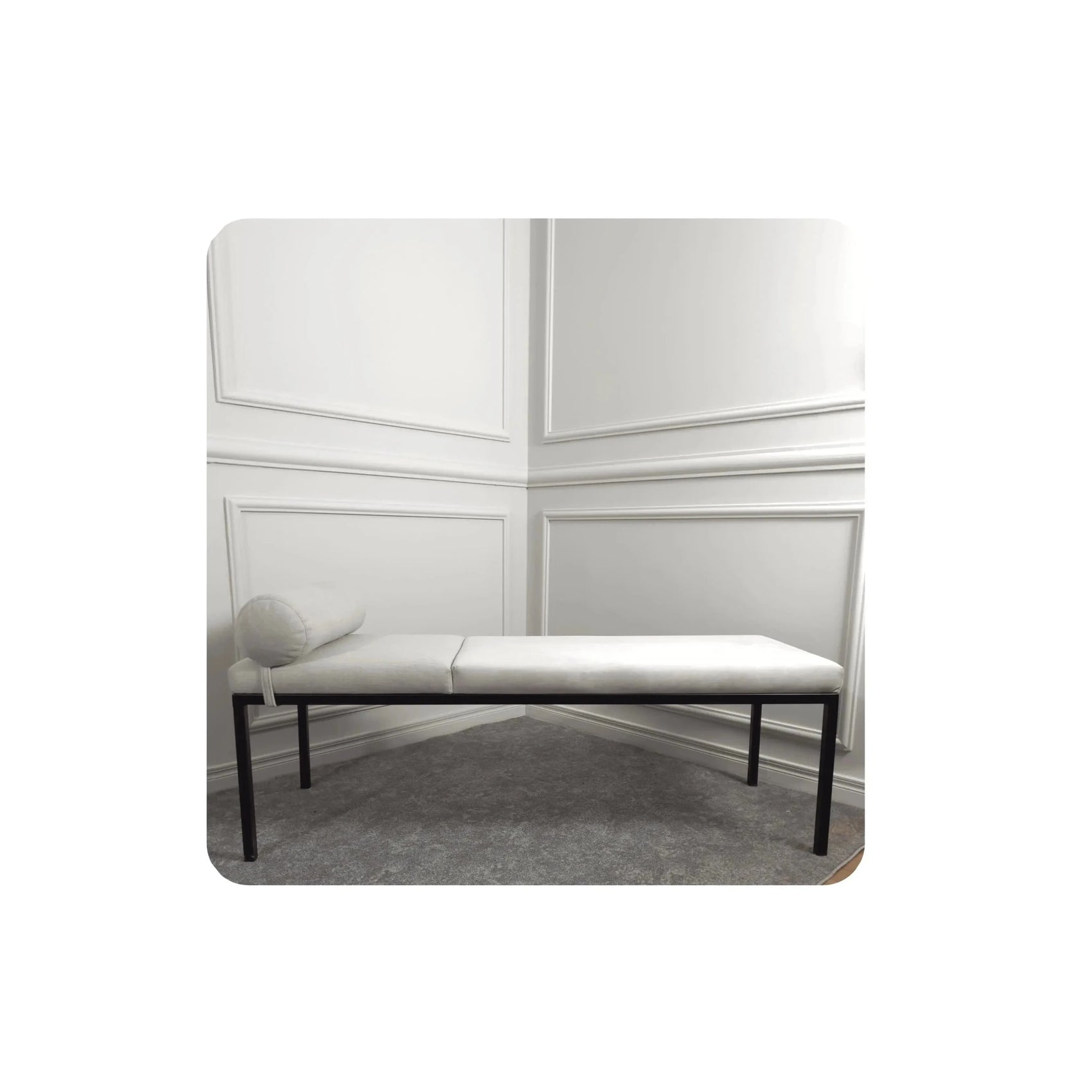 Recamier bege com almofada roliça lateral e base preta.