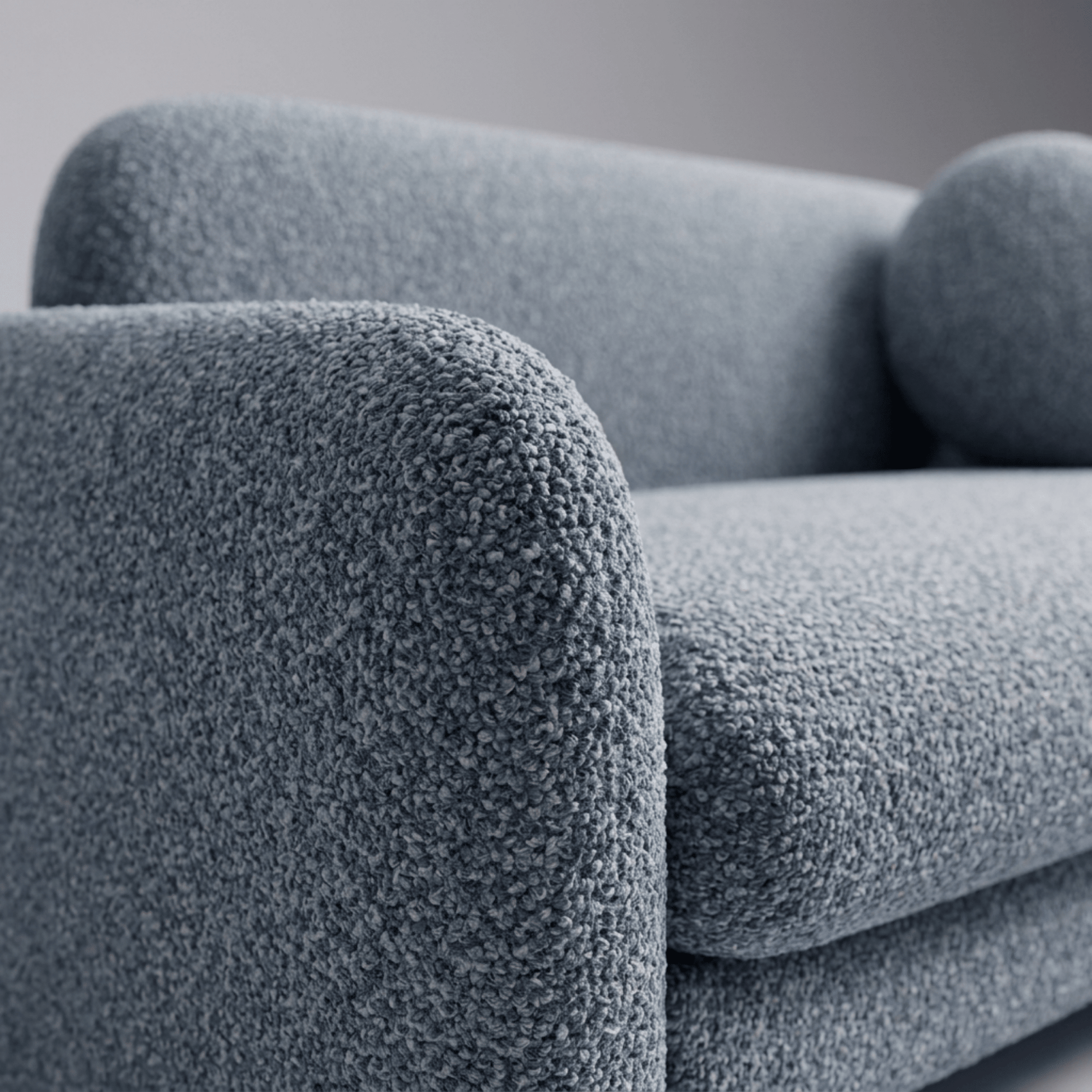 Sofá-cama azul escuro com detalhe do braço volumoso e tecido texturizado
